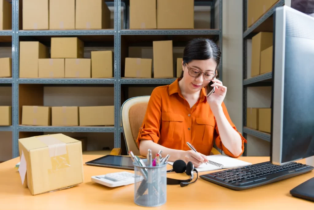 Nhân viên Logistics xác nhận thông tin lô hàng qua điện thoại tại kho